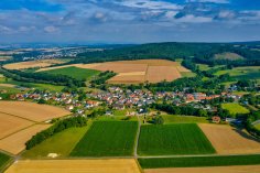 Luftaufnahme Asterode Luftaufnahme des Stadtteils Asterode im Sommer. Der Himmel ist leicht bedeckt, im Vordergrund zwei grüne Felder, im Hintergrund ist der Stadtteil Neukirchen zu erkennen.