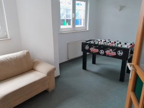 Bild Jugendtreff der Stadt Neukirchen, links ist ein Sofa zu sehen und rechts steht ein Kickertisch