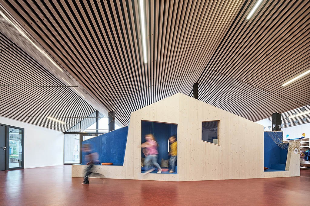 KiTa Riebelsdorf, ein Holzspielhaus mit spielenden Kindern.