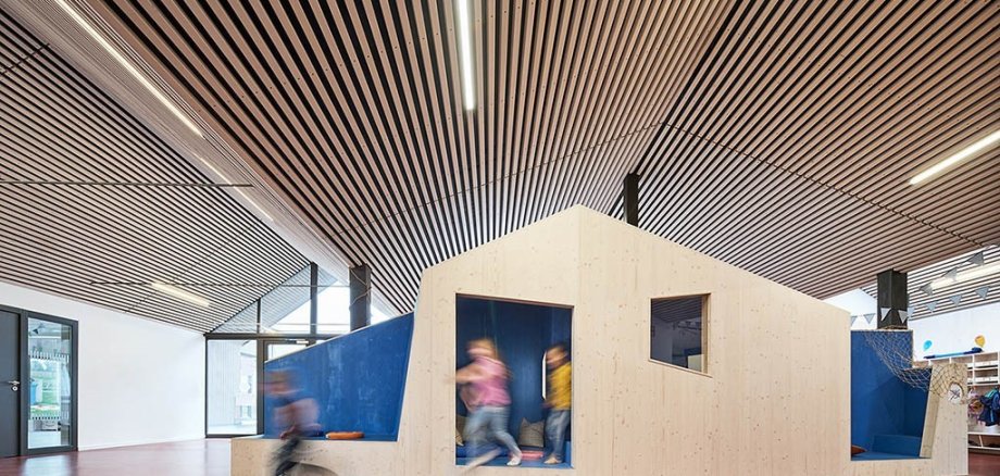 KiTa Riebelsdorf, ein Holzspielhaus mit spielenden Kindern.